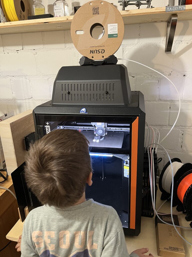 Die Nachwuchsreparateure schauen sich den 3D Druck an. 